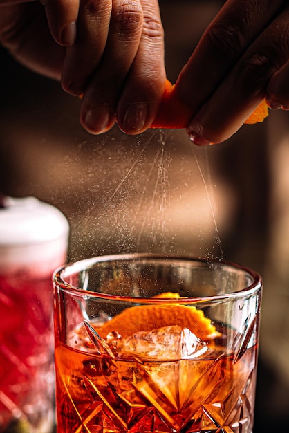 Sprinkling negroni cocktail from orange peel