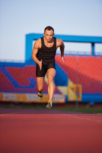 Sprinter leaving starting blocks on the running track. Explosive start.