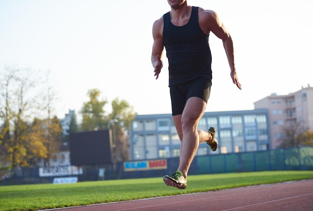 Sprinter leaving starting blocks on the running track. Explosive start.