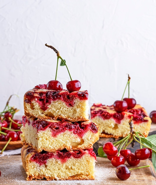 Square biscuit slices of a pie with cherries 