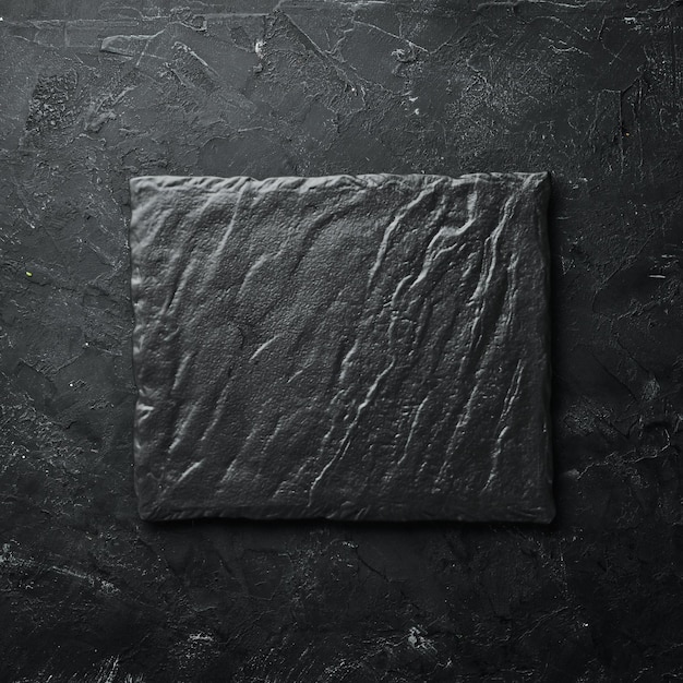 Photo square black stone dish on a black stone background top view free space for your text