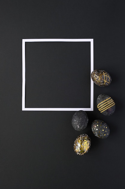 Square frame with black easter eggs with gold pattern on black background. Luxury easter