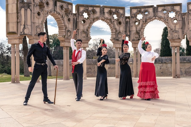 In a square in front of some ornamental arches a flamenco master instructs his apprentices Flamenco