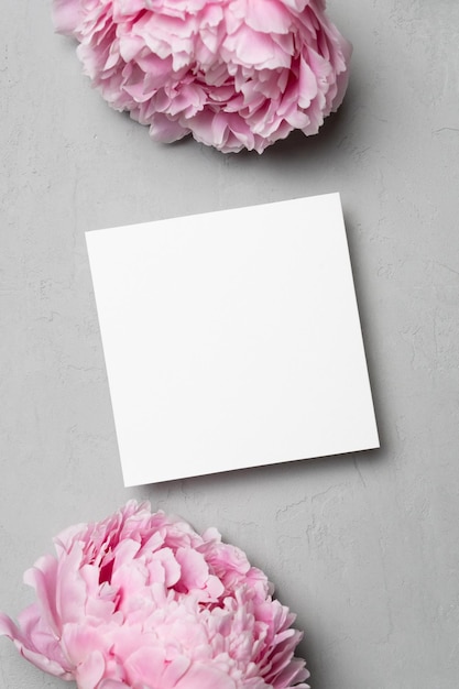 Square paper card mockup with flowers top view with copy space