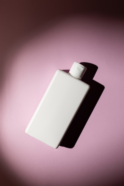 Square shampoo bottle on a pink background, mock up for business