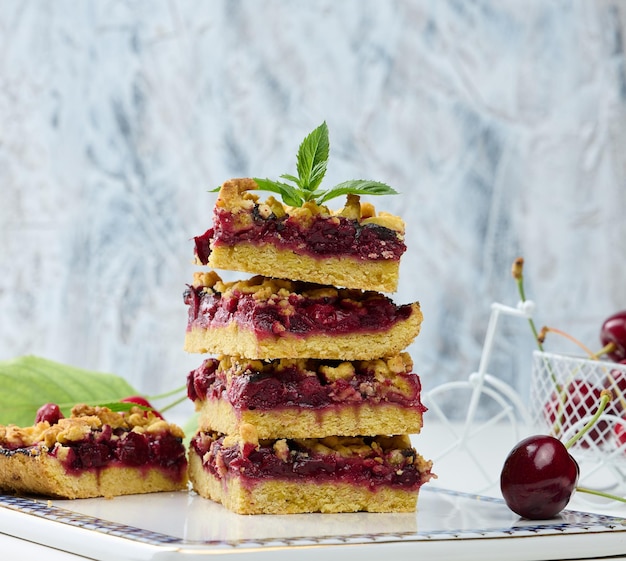 Square slices of cherry crumble lie in a stack on a white backgroundx9