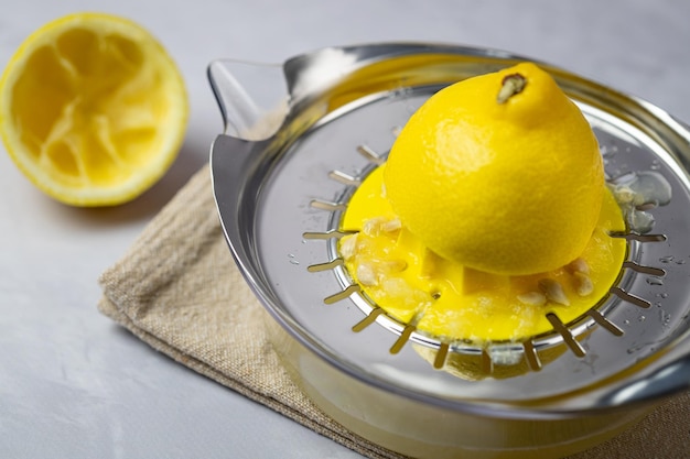 Squeezing lemon using a manual kitchen squeezer View from above