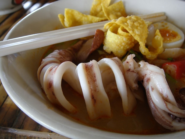 Squid in Asian spicy seafood noodle soup