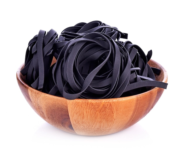 Squid ink pasta in bowl on white background