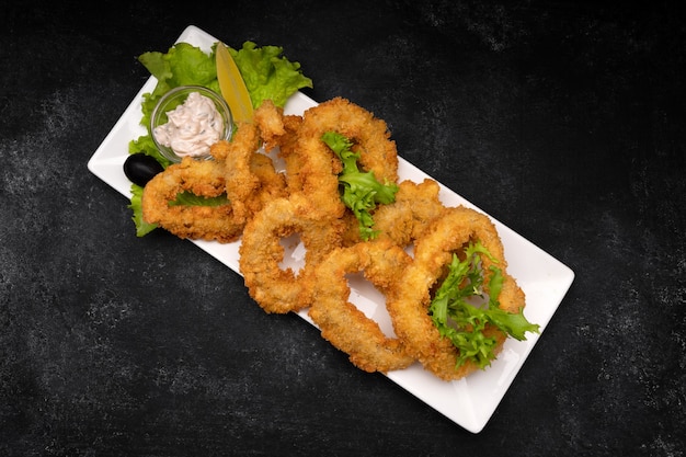 Squid rings fried in batter on a dark background soft focus