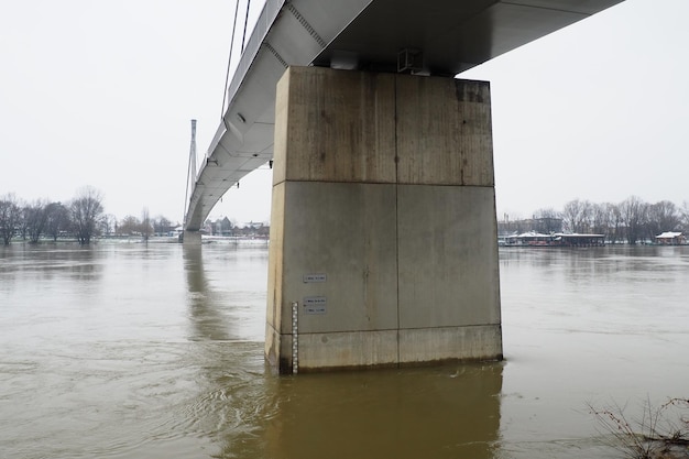 Sremska Mitrovica Serbia 01272023 Bridge over the river Sava Flooding after heavy rains and melting snow A swift flow of muddy water Hydrological scale for measuring the level of water