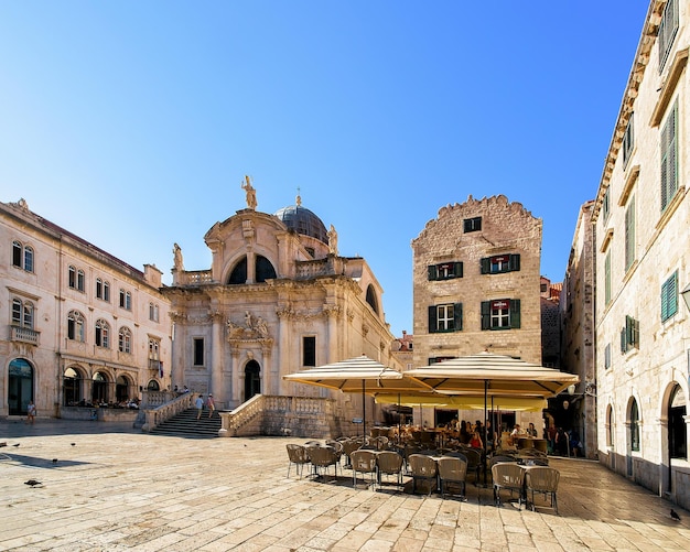 St Blaise's church on Stradun Street and people in the  cafe at the Old city of Dubrovnik, Croatia