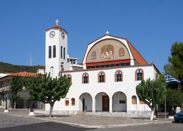 St George's Church with a chapel and bell tower on waterfront of resort town of Marmari in Greece