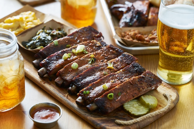 St Louis style bbq ribs on a tabletop with sweet tea, beer and mac & cheese