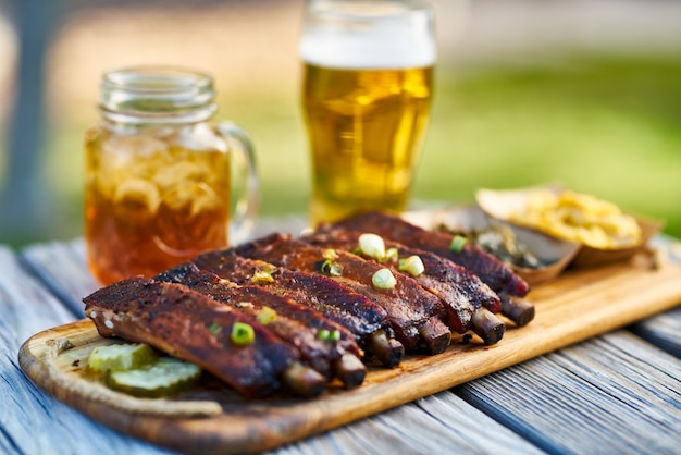 St louis style bbq ribs with collard greens and mac & cheese outside on picnic table during sunny summer day