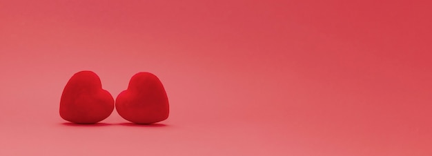 St.Valentine day concept. two red velvet hearts on a gradient red background . copy space. banner size.