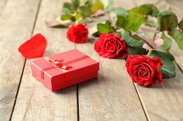 St Valentines Day concept Fresh red roses and gift box on wooden table