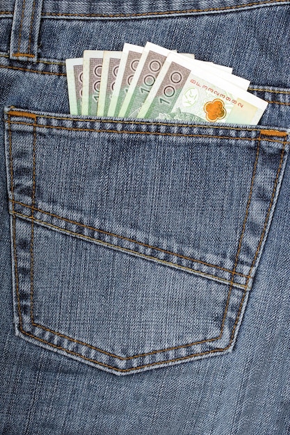 A stack of 100 and 100 euro banknotes in a blue jeans pocket