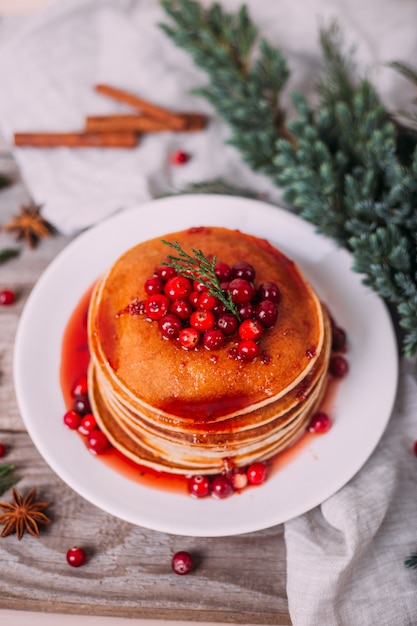 Stack of american pancakes with cranberry and jam. Christmas breakfast