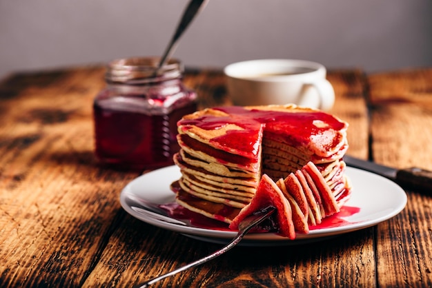 Stack of american pancakes with red berry jam