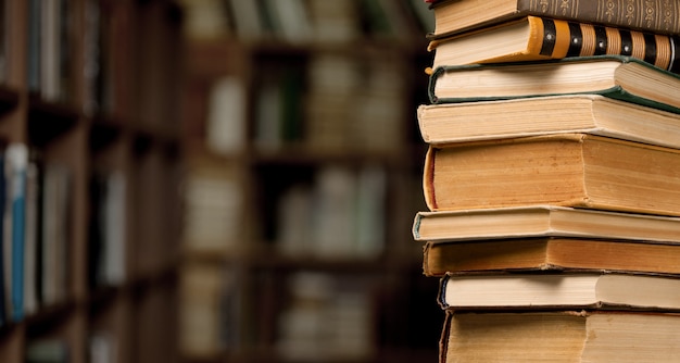 The stack ancient books on a library background