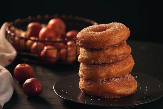 Stack of assorted donuts on a plate with milk on black background