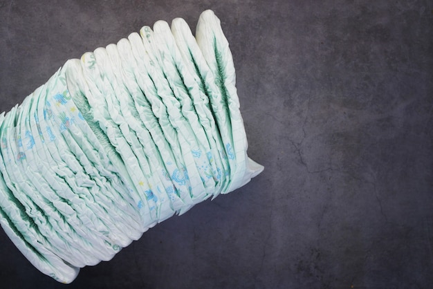 Stack of baby diaper on black surface