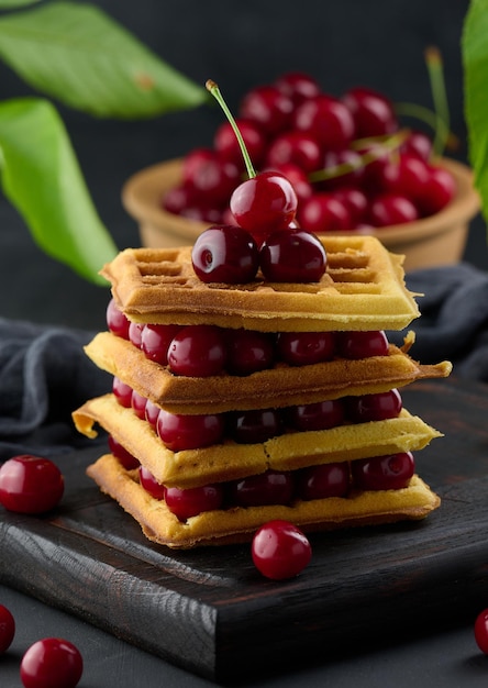 Stack of baked Belgian waffles with ripe red cherries breakfastx9