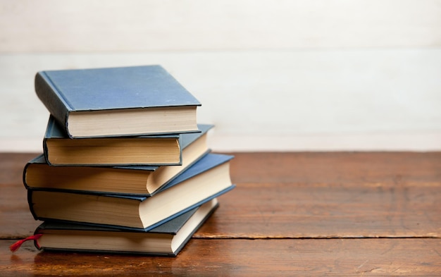 stack of blue books on old wooden shelf with dark background