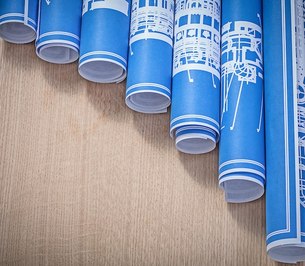 Stack of blue engineering drawings on wood board close up view