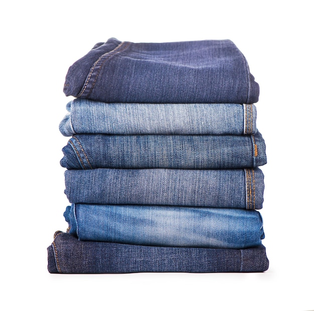 Stack of blue jeans on a white background