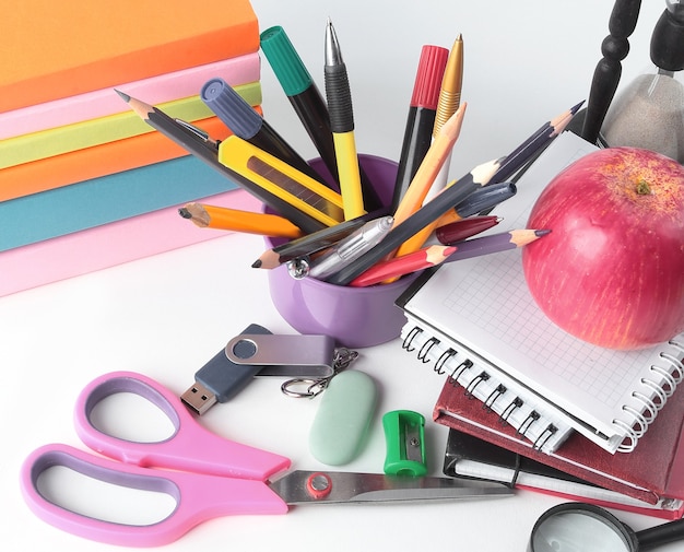 Stack of books and colorful school supplies on white backgroundphoto with copy space