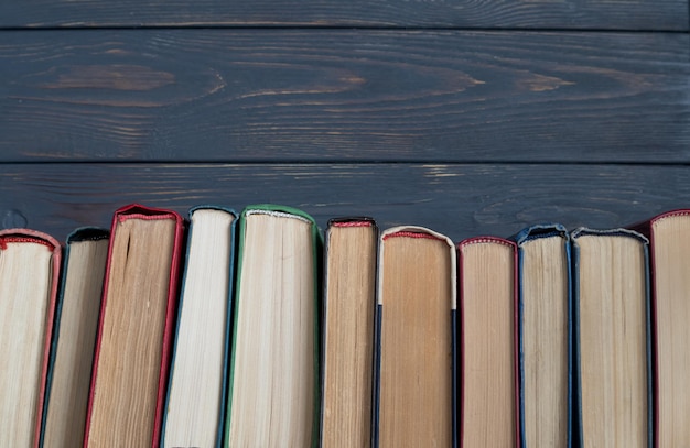 A stack of books on a gray wooden background the concept of reading books on paper