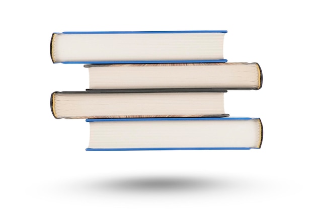 Stack of books isolate on white background A stack of books of varying thickness falls casting a shadow Books are isolated on a white background hanging in the air