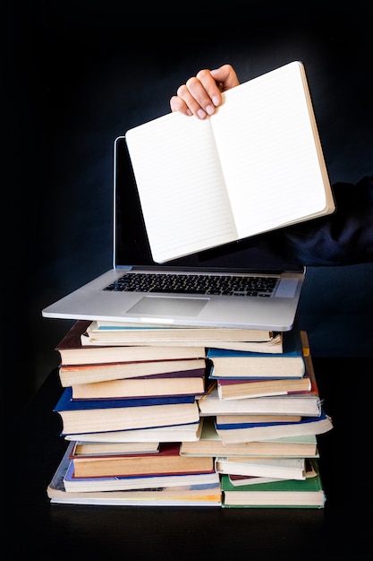 Stack books laptop black background notebook hand