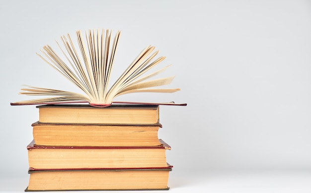 Stack of books and an open book with yellow pages 