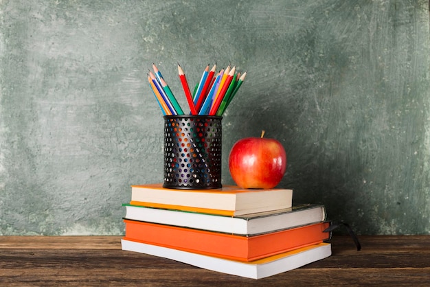 Stack of books and stationery on background of the school board Education and back to school concept