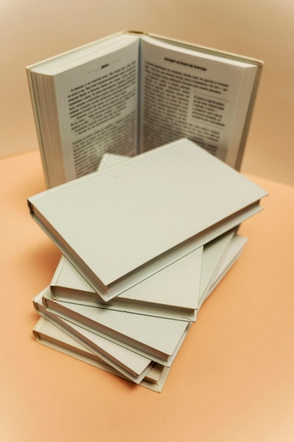 A stack of books on the table on a light pink background, study, back to school, library