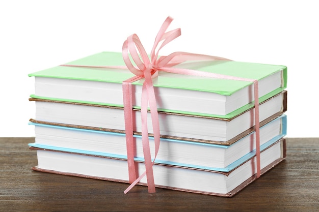 Stack of books with ribbon on light background