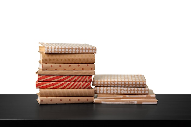 Stack of books on wooden table against white background