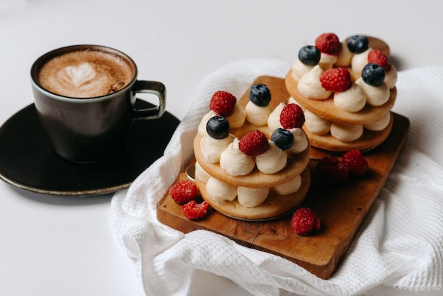 A stack of cakes with raspberries and blueberries on top