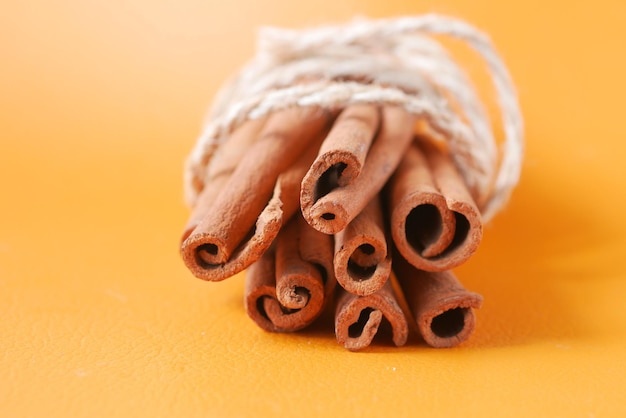 Stack of Cinnamon sticks on orange background