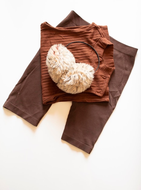 Stack of clothes with ear warmers on a white background minimal flat lay