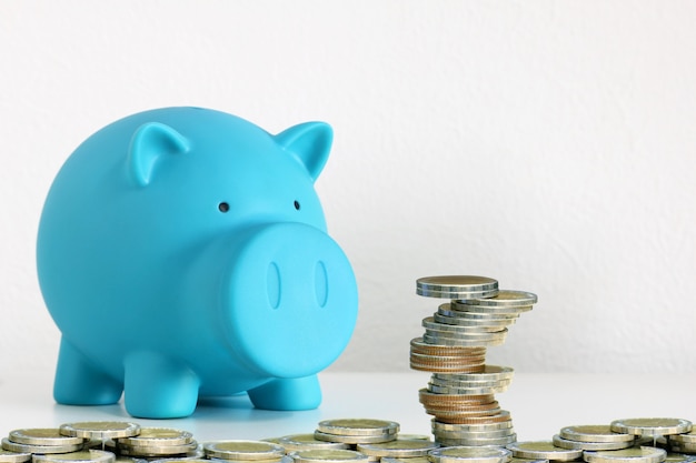 Stack of coins with piggy bank .