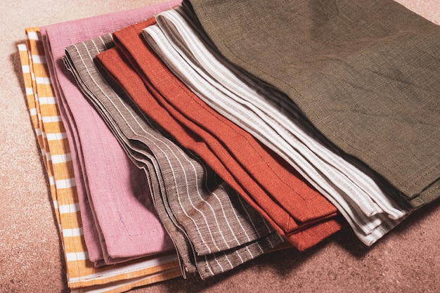 Stack of colored serving napkins on beige background