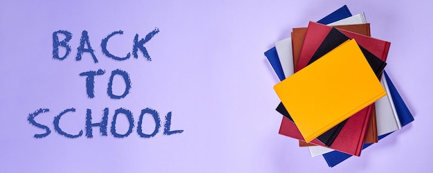 Stack of colorful books on purple background