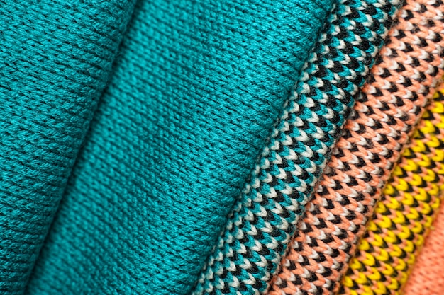 Stack of colorful knitted fabric, knitted winter clothes. Multicolored knitwear fabric background