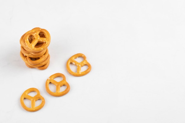 Stack of delicious salted dry pretzels on white surface