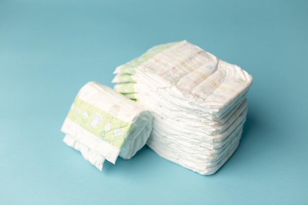 Stack of diapers on light blue background