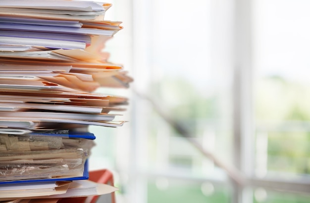 Stack of documents and folders on blurred background